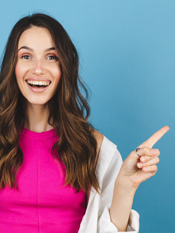 Frau mit braunen Haaren und pinken Top zeigt mit einem erstauten Blick auf den headline-Text "Weiterempfehlen lohnt sich".